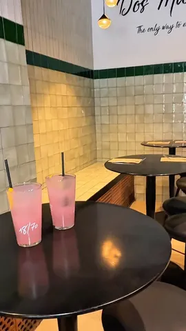 Dos limonadas rosas en una mesa del local, con las paredes de azulejo blanco y verde